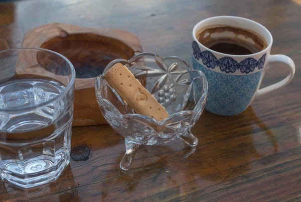 geleneksel Yunan kahve Yunan çerez fincan su ahşap bir masa üzerinde bir kül tablası