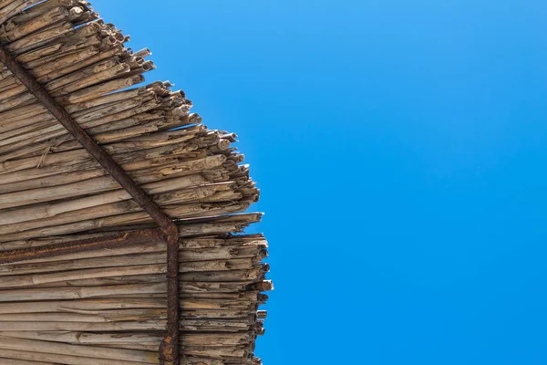 İpucu o saman bir şemsiye ve açık yaz gökyüzü görünümü. bakış açısı