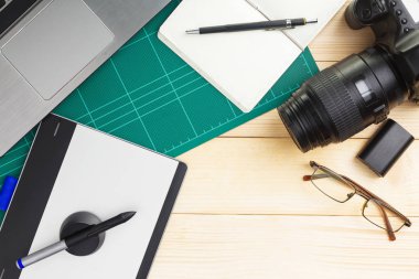Grafik tasarımcı ekipman ile ahşap masa üzerinde üstten görünüm başı işleri ve becerikli alet. düz yatıyordu stili.