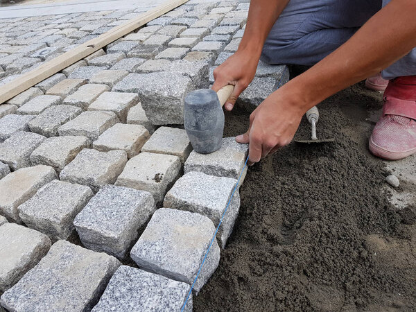 Construction worker arranging a pavement for renovating a street in an old city center