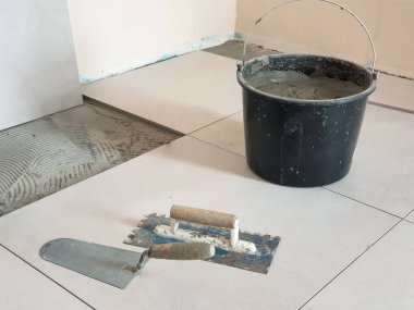 Araçlar Mala, mala ve kova yerdeki karoların düzenlemek için hazırlanan yapıştırıcı ile çentikli.