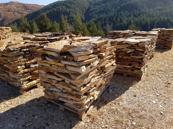 Natural stone tiles slabs stacked on pallets in a stone quarry.