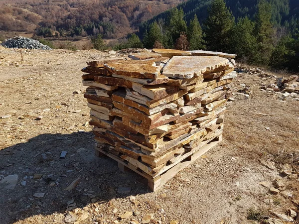 Natural stone tiles slabs stacked on a pallet ready for transport in a stone quarry.