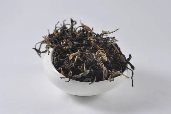 Chinese black tea in tea ware. Dry tea leaf. Product photo of Chinese tea. Tea and infusions. Heap of dry tea.