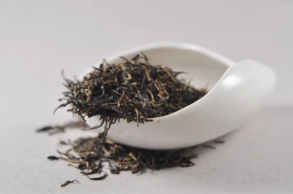 Chinese black tea in tea ware. Dry tea leaf. Product photo of Chinese tea. Tea and infusions. Heap of dry tea.