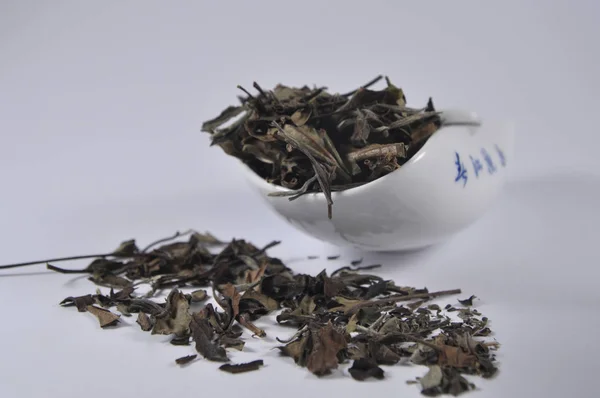 Chinese white tea in tea ware. Dry tea leaf. Product photo of Chinese tea. Tea and infusions. Heap of dry tea.