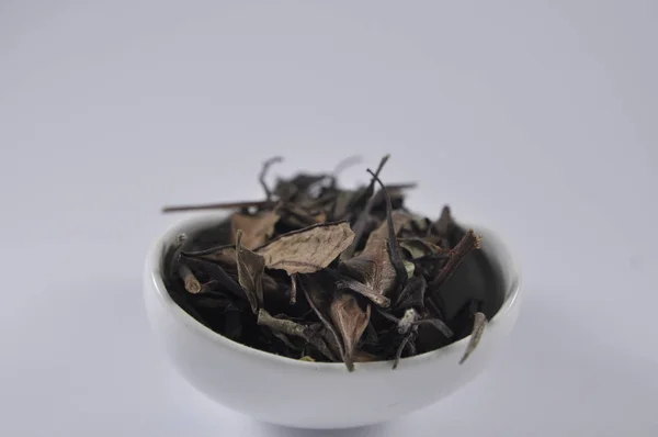 Chinese white tea in tea ware. Dry tea leaf. Product photo of Chinese tea. Tea and infusions. Heap of dry tea.