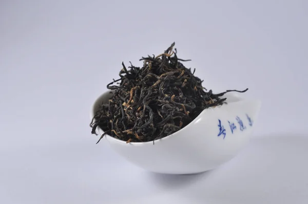 Chinese black tea in tea ware. Dry tea leaf. Product photo of Chinese tea. Tea and infusions. Heap of dry tea.