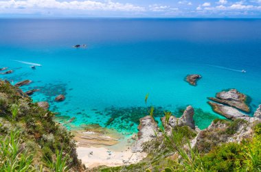 Ufuk hava panoramik manzaralı ve şaşırtıcı tropikal mavi masmavi turkuaz su deniz, rock cliff çim hill, yatlar tekneler, mavi gökyüzü arka plan, Capo Vaticano Calabria, Güney İtalya acele