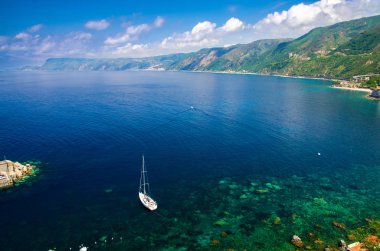 Küçük bir balıkçı köyü Chianalea di Scilla Castle yakınındaki mavi lagün beyaz yat gemi tekne kaya Ruffo, Akdeniz Tiren Denizi sahil kıyısında, Calabria, Güney İtalya hava üstten görünüm