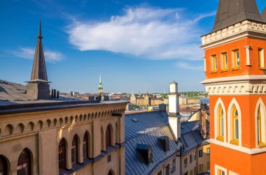Geleneksel tipik İsveç çatılar evler binalar ile tavan ve renkli duvarlar Sodermalm Soder adada Gamla Stan kilisede Kulesi ile mavi gökyüzü beyaz bulutlar arka plan, Stockholm, İsveç