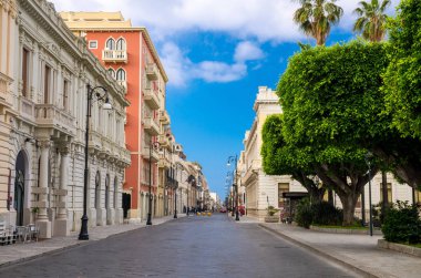 Yaya Turizm caddesi Corso Giuseppe Garibaldi eski geleneksel binalar, lambalar ve tarihi merkezinde şehrin Reggio di Calabria, Güney İtalya, yeşil ağaçların