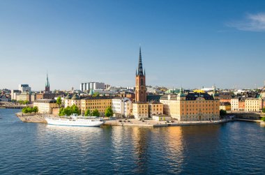 Bölgesinin Riddarholmen Riddarholm Kilisesi ve tipik İsveç Gotik binalar, Stockholm, İsveç'te Sodermalm Island'dan Lake Malaren denizde yelken tekne gemi hava panoramik üstten görünüm
