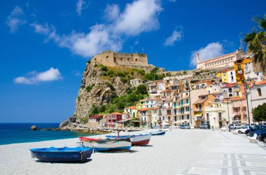 Tiren Denizi kumlu plaj sahil kıyısında güzel sahil kasabası Scilla geleneksel evleri ile renkli tekneler ve eski ortaçağ kalesi kaya Castello Ruffo, Calabria, Güney İtalya Balık tutma