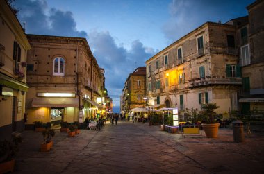 Kafe ve restoranlar beldesi, balkonlu binalar, vazolar çiçek ve de akşam, günbatımı, alacakaranlık, alacakaranlık mavi gökyüzü, Tropea, Calabria, Güney İtalya ile çekim windows ile sokaklarında