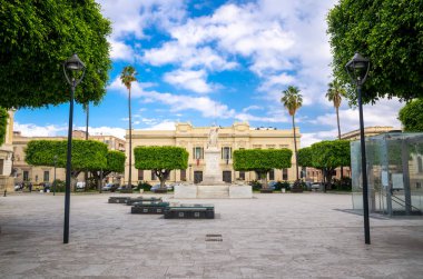 Archeologic alan Ipogea Piazza ili ve şehrin Reggio di Calabria, Güney İtalya tarihi merkezinde yeşil palmiye ağaçlarında bina Italia kare,