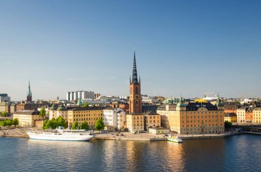 Bölgesinin Riddarholmen Riddarholm Kilisesi ve tipik İsveç Gotik binalar, Stockholm, İsveç'te Sodermalm Island'dan Lake Malaren denizde yelken tekne gemi hava panoramik üstten görünüm