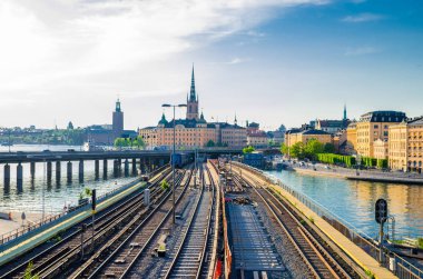 Eski tarihi kasabada Gamla Stan ve Stockholms stadshus Belediye Binası arka plan, İsveç Stokholm demiryolu Metro parça ve trenler Lake Malaren su Riddarholmen Adası, kilise, doğru üzerinde köprü