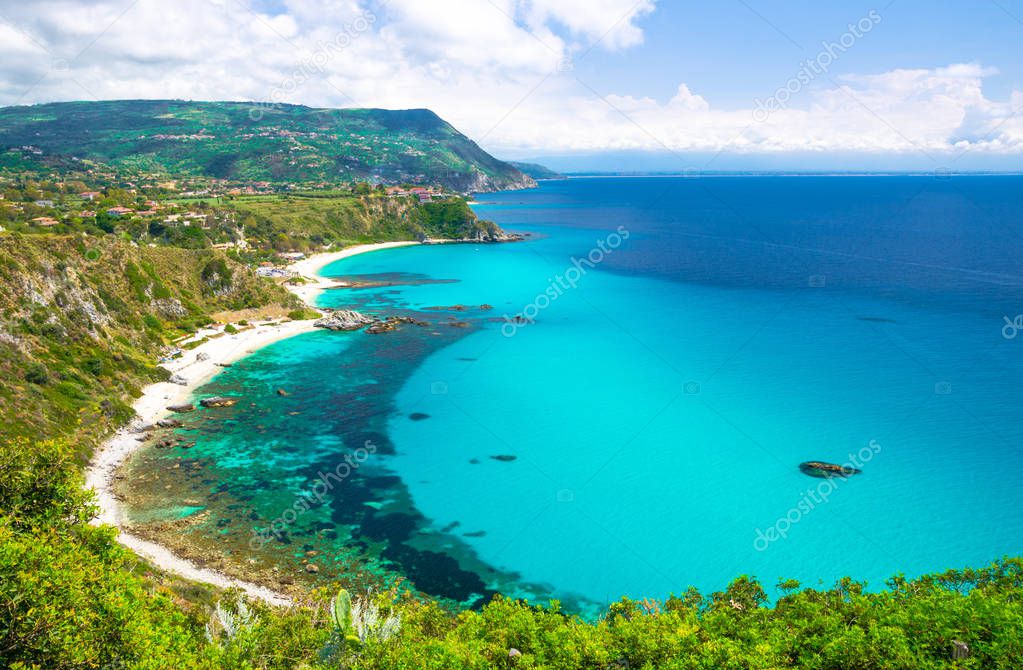 Aerial amazing tropical view of turquoise gulf bay, sandy beach, green mountains and plants, blue sky white clouds background from cliffs platform Cape Capo Vaticano Ricadi, Calabria, Southern Italy
