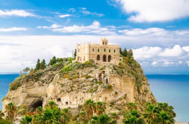 Manastırın kutsal kilise Santa Maria dell Isola Tiren Denizi ve yeşil palmiye ağaçları, mavi gökyüzü beyaz bulutlarda güneşli bir gün, Tropea, Vibo Valentia, Calabria, Güney İtalya ile kaya üzerine