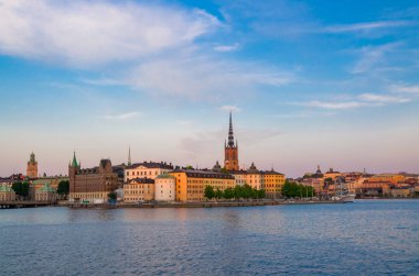 Riddarholmen Adası ilçe göl Malaren su Kungsholmen kopya alanı ile Stockholm, İsveç demirlemiş tekne gemiyi Riddarholm kilise kulesi ve tipik İsveç renkli Gotik binalar,