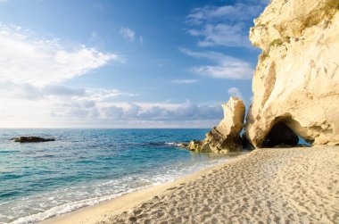 Taş kemer kapaklı mağara Tiren Denizi kumsal kıyı kıyı şeridi mavi gökyüzü ve beyaz bulutlar, Tropea kentindeki Vibo Valentia, Calabria, Güney İtalya ile yakınındaki yeşillik