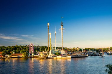 Djurgarden Adası ve Tivoli atlıkarınca eğlence konumlar Grona Lund (Luna Park) yeşil orman ve mavi gökyüzü arka plan ve göl Malaren su Skeppsholmen adadan, Stockholm, İsveç görüntülemek