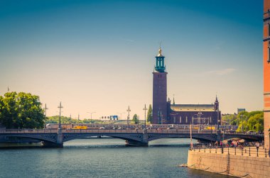 Stockholm City Hall (Stadshuset) kule bina Belediye Meclisi ve Nobel Ödülü Kungsholmen Adası ve göl Malaren köprüden yeri açık güneşli mavi gökyüzü, İsveç ile su