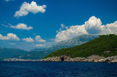 Boka Kotor Körfezi su, Herceg Novi şehir ve Mount Orjen beyaz bulutlar, Karadağ ile mavi gökyüzü önünde Dinar Alpleri dağ aralığının görünümünü
