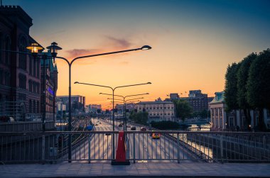 Araba Centralbron Cadde Köprüsü'Malaren göl üzerinde acele lambalar ışıkları günbatımı, alacakaranlık, alacakaranlık, Riddarholmen ve Stadsholmen Adası Gamla Stan, Stockholm, İsveç