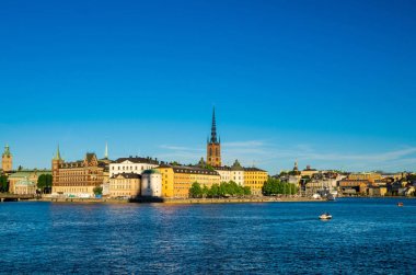 Riddarholmen Adası ilçe göl Malaren su Kungsholmen kopya alanı ile Stockholm, İsveç demirlemiş tekne gemiyi Riddarholm kilise kulesi ve tipik İsveç renkli Gotik binalar,
