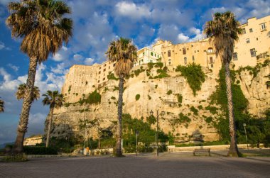 Tropea şehir renkli taş binalar yüksek büyük kayalar, üstünde palmiye ağaçları ve sokak lambası, Vibo Valentia, Calabria, Güney İtalya