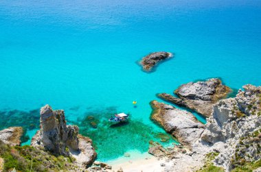 Alt yelken drift ve kauçuk tekne park deniz cape Capo Vaticano Ricadi, Calabria, Güney İtalya çok uzak olmayan kayalar arasında lagoon mavi masmavi turkuaz su yüzeyi üzerinde gölgeler ile balıkçılık Yat