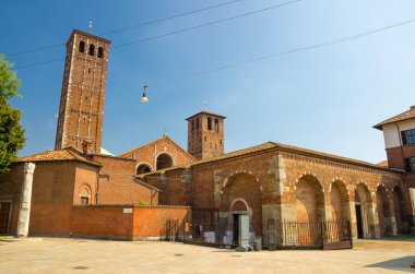 Sant'Ambrogio kilise tuğla çan kulelerinin ve Devil's sütun Meydanı, Milan, Lombardiya, İtalya ile bina Bazilikası