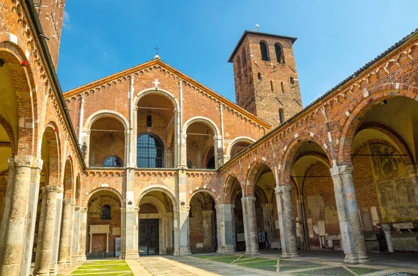 Çan kulelerinin, avlu, kemerler, mavi gökyüzü ile Sant'Ambrogio kilise tuğla bina Bazilikası arka plan, Milan, Lombardiya, İtalya