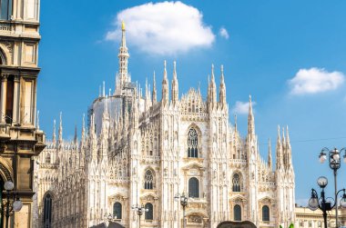 Duomo di Milano katedral cephesi beyaz duvarlar, kuleler, pervaz ve Piazza del Duomo Meydanı, sıva çalışmaları ile görüntülemek Via Mercanti mavi gökyüzü arka plan ile Milano şehir merkezine, İtalya
