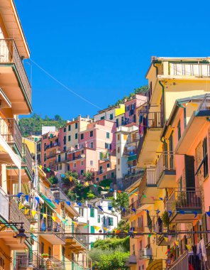 Çok renkli renkli binalar evleri bayrakları satırları, Manarola tipik geleneksel balıkçı köyü Milli Parkı Cinque Terre, mavi gökyüzü arka plan balkon, La Spezia eyaletinin, Liguria, İtalya