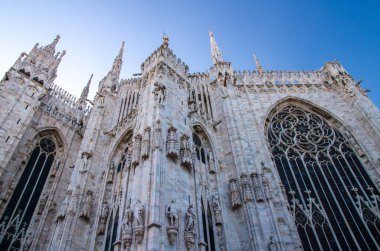 Duomo di Milano Katedrali ile yüksek windows, kuleler, pervaz ve sıva iş, beyaz duvarları, aşağıdan mavi gökyüzü arka plan ile Milano şehir merkezine, İtalya görüntülemek
