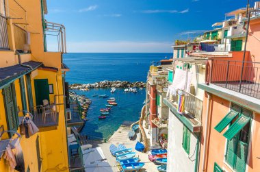 Üstten görünüm teknelerle balıkçılık renkli, çok renkli küçük liman, balkon ve çekim windows Riomaggiore köyü Ulusal Park Cinque Terre, ufuk Ligurya Denizi, Liguria, İtalya ile evler