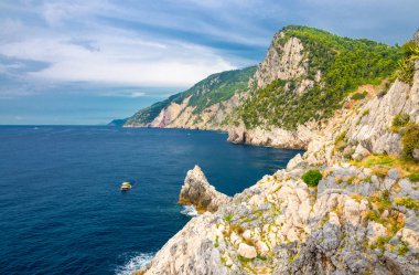 Grotta di Lord Byron mavi suyla, kıyıları kayalıklarla, sarı teknesi ve mavi gökyüzü Portovenere kasabası, Ligurian denizi, Riviera di Levante, Ulusal Park Cinque Terre, La Spezia, Liguria, İtalya