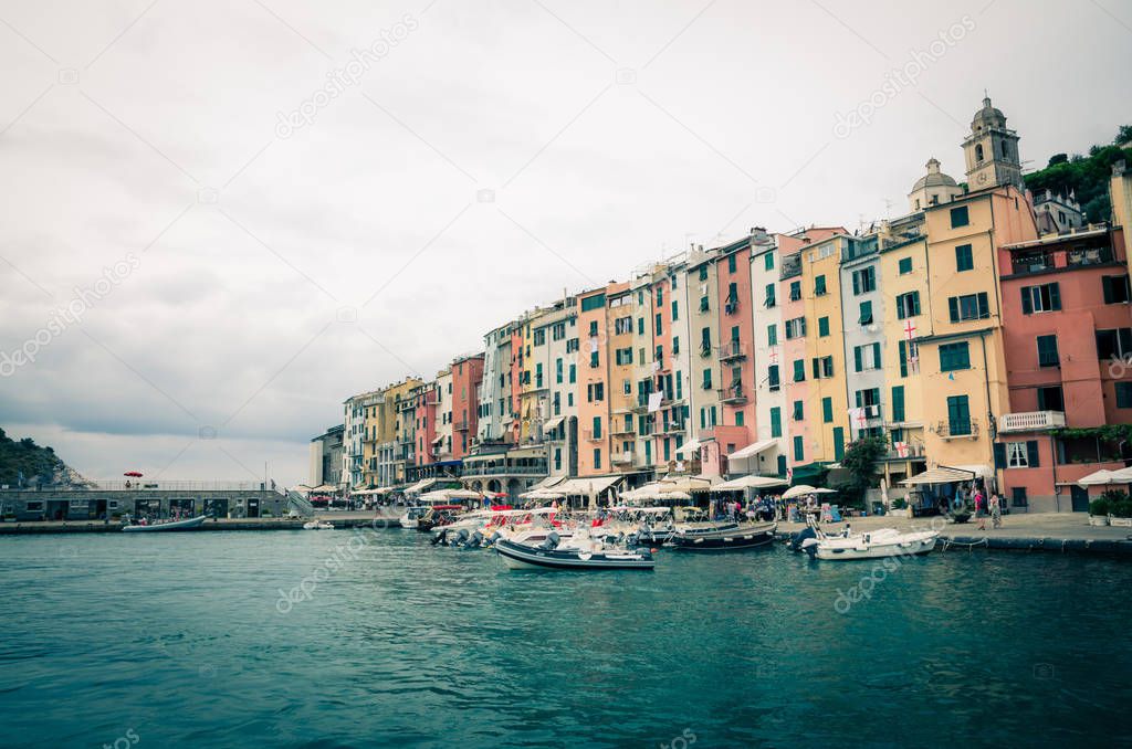 Row of colorful multicolored buildings houses of Portovenere coastal town village and boats in harbor of Ligurian sea, Riviera di Levante, National park Cinque Terre, La Spezia, Liguria, Italy