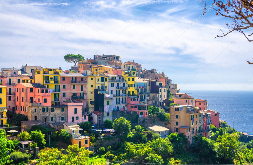 Corniglia traditional typical Italian village with colorful multicolored buildings houses on rock cliff and Genoa Gulf, Ligurian Sea background, National park Cinque Terre, La Spezia, Liguria, Italy