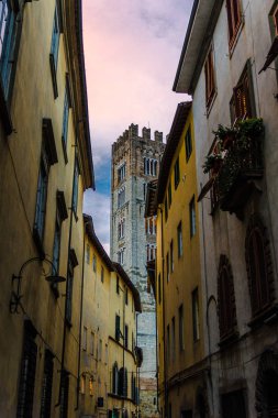 Eski ortaçağ kenti Lucca tarihi merkezinde dar sokak üzerinden Chiesa di San Frediano katolik kilisesinin Çan kulesi, akşam manzarası, Toskana, İtalya