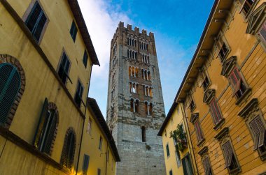 Chiesa di San Frediano katolik kilisesi çan kulesi eski ortaçağ kenti Lucca, akşam görünümü, Toskana, İtalya tarihi merkezinde dar sokaktan aşağıda görünümü