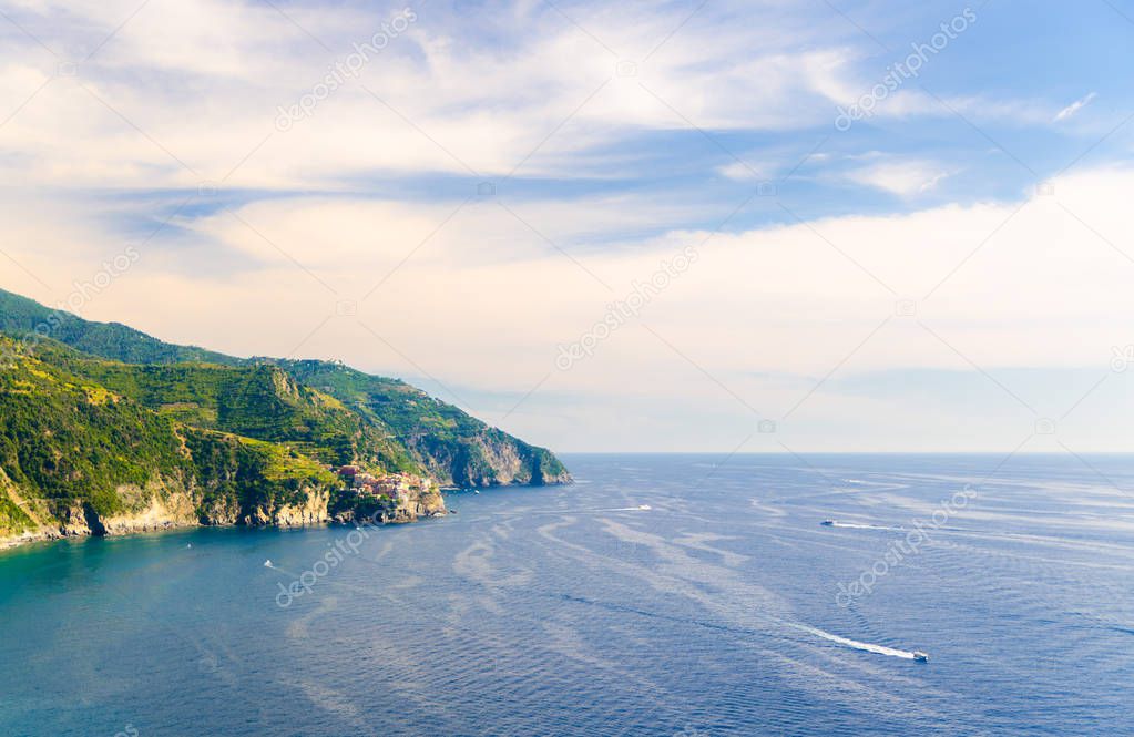 Aerial top panoramic view of Manarola village on cliff and Gulf of Genoa, Ligurian Sea, coastline of Riviera di Levante, National park Cinque Terre, blue sky copy space, La Spezia, Liguria, Italy