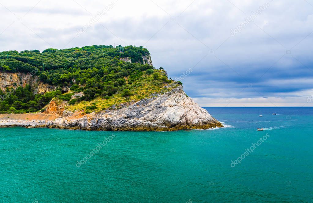 Palmaria island with green trees, cliffs, rocks and blue turquoise water of Ligurian sea with dramatic sky background, Riviera di Levante, National park Cinque Terre, La Spezia, Liguria, Italy