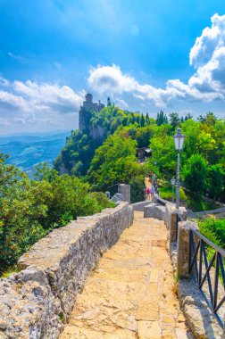 Seconda Torre La Cesta Cumhuriyeti San Marino ikinci kale kule yeyeşil ağaçlar, mavi gökyüzü beyaz bulutlar arka plan, dikey yönelim ile Mount Titano kaya tuğla duvarlar ile Taş yol