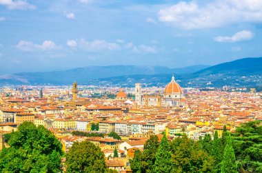 Duomo Cattedrale di Santa Maria del Fiore katedrali ile Floransa şehrinin en iyi panoramik manzarası, turuncu kırmızı kiremitli çatıları ve tepeleri olan evler, mavi gökyüzü beyaz bulutları, Toskana, İtalya