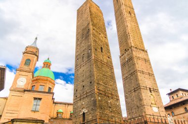 Two medieval towers of Bologna Le Due Torri: Asinelli and Garisenda and Chiesa di San Bartolomeo Gaetano church on Piazza di Porta Ravegnana square in old historical city centre, Emilia-Romagna, Italy clipart