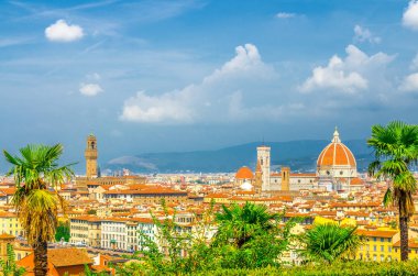 Duomo Cattedrale di Santa Maria del Fiore katedrali ile Floransa şehrinin en iyi panoramik manzarası, turuncu kırmızı kiremitli çatılı ve palmiye ağaçları, mavi gökyüzü beyaz bulutlar, Toskana, İtalya ile binalar
